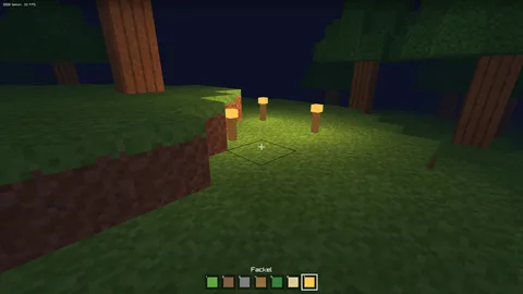 Eine Blockwelt mit Bäumen auf grüner Wiese, unten eine Leiste mit Blöcken zum Bauen