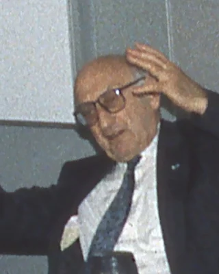 Friedrich L. Bauer 1995: ein älterer Mann mit Halbglatze und großer Brille in dunklem Sakko, Hemd und Krawatte, beim Sprechen eine Hand am Kopf.