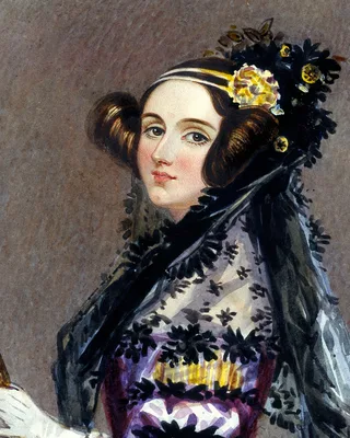 Ada Lovelace um 1840, Aquarell: eine junge Frau mit dunklem, über den Ohren aufgestecktem Haar, einem goldenen Band und Blumen im Haar und einem schwarzen Spitzenschleier über den Schultern, den Blick zum Betrachter.