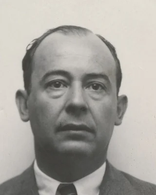 Schwarzweißes Ausweisfoto von John von Neumann aus den 1940er Jahren: ein Mann mit hoher Stirn in Anzug und Krawatte.