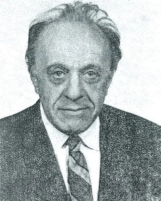 Karl Menger 1970: ein älterer Mann mit zurückgekämmtem grauem Haar in Anzug und gestreifter Krawatte, mit leichtem Lächeln.